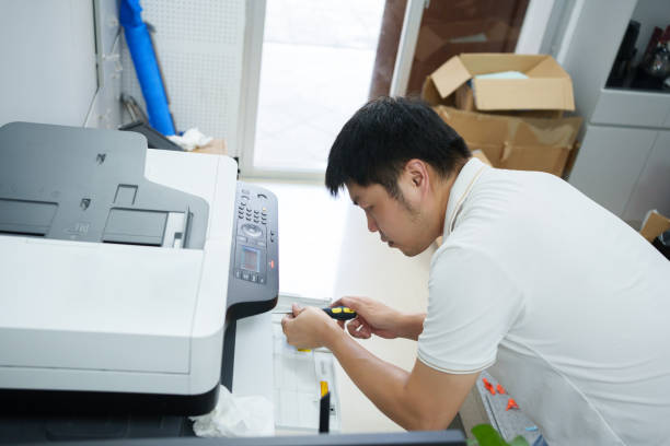 Asian man repairing printer